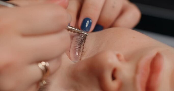 Lashmaker does the eyelash lamination procedure for the client in the beauty salon, cosmetic services, beauty care procedures, 4k 60p Prores HQ