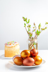 Easter cake with sweet icing and golden eggs on white plate.