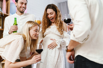 Pregnant woman making fun with her friends during gender reveal party