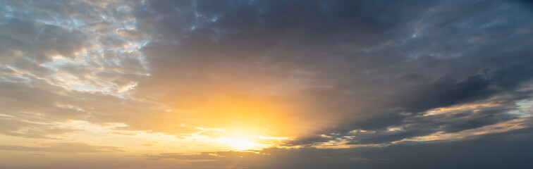 Fototapeta na wymiar Dark clouds and orange sun at dusk