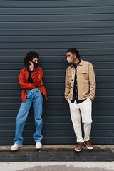 full length of trendy young african american couple in protective masks posing outside