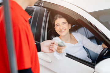 Driver customer pay fuel cost by credit card to staff worker for in gas station happy smile.