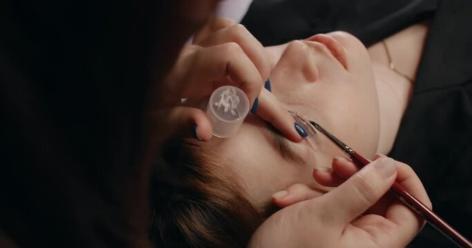 Lashmaker does the eyelash lamination procedure for the client in the beauty salon, cosmetic services, beauty care procedures, 4k 60p Prores HQ