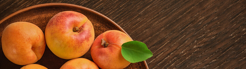 Harvest appetizing apricot in bowl with free space for text