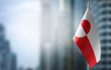 A small flag of Greenland on the background of a blurred background © butenkow