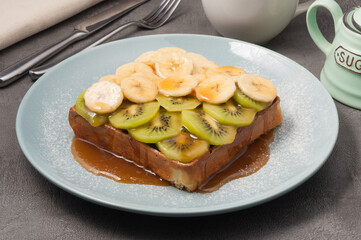 waffle with kiwi and banana drizzled with maple syrup