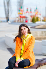 Fototapeta premium Happy brunette young woman in good mood walks outside. Good-looking Millennial Hipster Girl wearing trendy vivid outfit having fun outdoors.