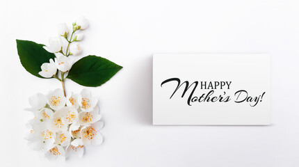 Composition of blooming flowers. Jasmine branch growing out of the circle of jasmine buds. Inscription Happy Mother's Day. Banner, poster for Mother's Day. Flat lay, top view, close up, copy space