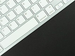 Top view above of  workplace with a white keyboard on the black background. Copy space for your text, Flat lay. Office work and office conception.
