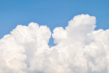 Obraz na płótnie Canvas White cumulus clouds on cloudscape. Beautiful huge soft cloud formation in clear blue sky