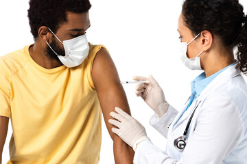 African american doctor in protective mask and latex gloves doing vaccination of patient isolated...