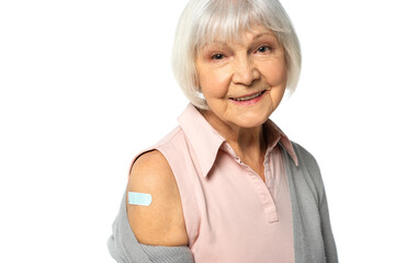 Elderly woman with adhesive plaster on arm looking at camera isolated on white