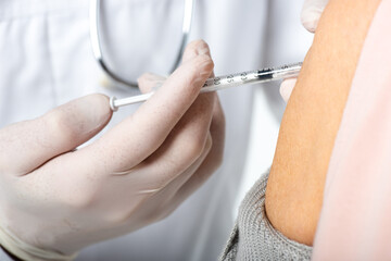 Cropped view of doctor in latex gloves doing injection with vaccine of senior patient isolated on white