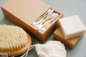 Zero waste concept, eco-friendly lifestyle, no plastic. Natural bathroom accessories: organic soap, natural brush, bamboo ear sticks, reusable cotton bags on green background.