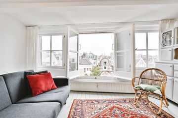 Interior of living room with white wall furnished with sofa and rattan chair on Persian rug with...