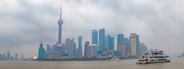 Panoramic view of Shanghai Pudong district skyline from the famous promenade the Bund with cloudy sky