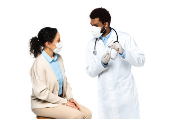 Fototapeta premium African american doctor in latex gloves holding jar with vaccine near patient isolated on white