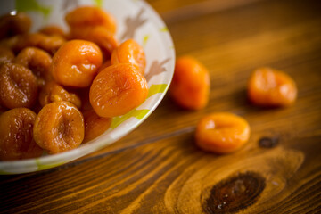 delicious dried apricots in a bowl on a wooden table