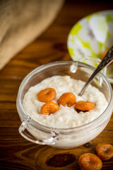 cooked boiled sweet oatmeal with dried apricots in a bowl