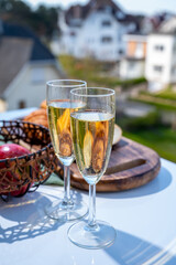 Drinking of brut champagne sparkling wine in flute glasses on outdoor bistro terrace in France