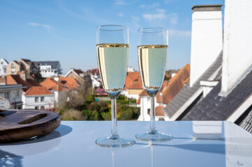 Obraz premium Drinking of brut champagne sparkling wine in flute glasses on outdoor bistro terrace in France