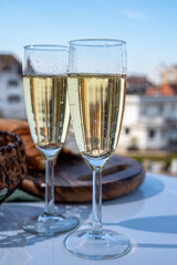 Drinking of brut champagne sparkling wine in flute glasses on outdoor bistro terrace in France
