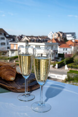 Drinking of brut champagne sparkling wine in flute glasses on outdoor bistro terrace in France