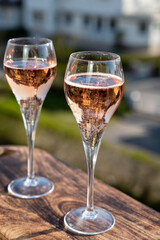 Drinking of rose champagne sparkling wine from flute glasses on outdoor terrace in France