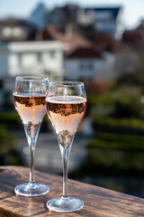Drinking of rose champagne sparkling wine from flute glasses on outdoor terrace in France