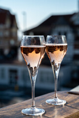 Drinking of rose champagne sparkling wine from flute glasses on outdoor terrace in France