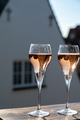 Drinking of rose champagne sparkling wine from flute glasses on outdoor terrace in France