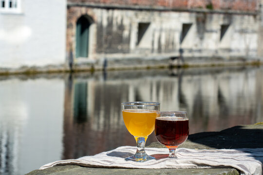 Tasting Of Belgian Beer On Open Cafe Or Bistro Terrace With View On Medieval Houses And Canals In Bruges, Belgium