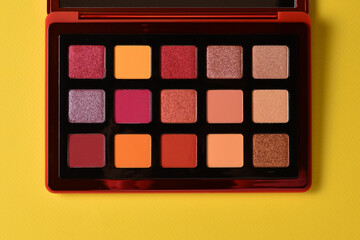 Eye shadow palette on orange background. Copy space.