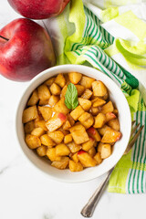Stewed apple with cinnamon and green fresh leaf of mint. White background and green towel