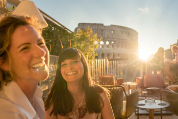 Two smiling women at sunset in Rome, Italy - obrazy, fototapety, plakaty