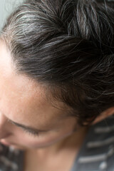 Fototapeta premium Top of woman's head: gray hair growing in