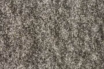 Natural pattern on the stone. The structure of gray granite with dark patches