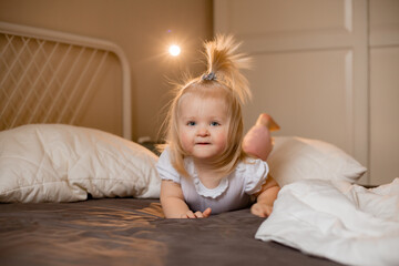 Fototapeta premium Happy little girl pragy in bed at home