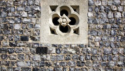 English grey flint wall with embedded cement decorative architectural feature
