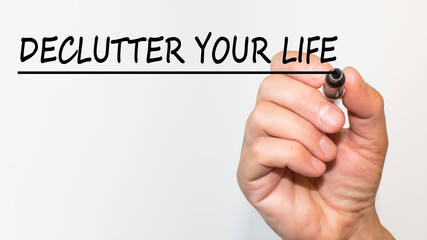 text DECLUTTER YOUR LIFE in a magnifying glass on a white background. business concept. office desk, calculator