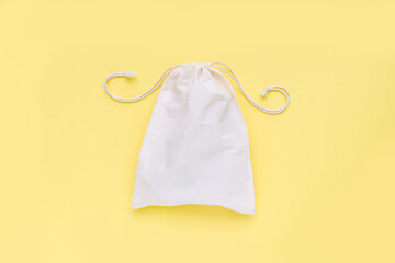 Reusable shopping bag on yellow background. Cotton shopper on yellow background