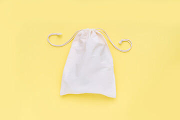 Reusable shopping bag on yellow background. Cotton shopper on yellow background