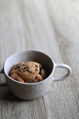 Bowl of chocolate chip cookies on wooden table. Selective focus.