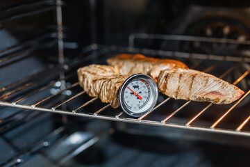 Thermometer in roast beef. Checks the temperature - obrazy, fototapety, plakaty