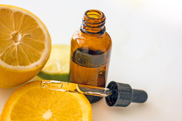Cosmetic product with vitamin C in a dark glass bottle with a pipette, natural cosmetics with essential oil of orange