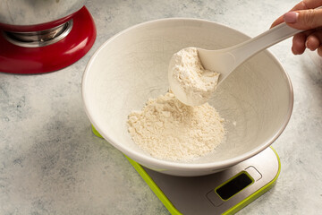 weighing flour for a cake on a scale. Home cooking