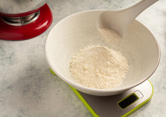 weighing flour for a cake on a scale. Home cooking