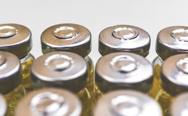 Obraz premium Develompent of new vaccine covid-19, close-up of coronavirus vaccine vials on white background, manufacture bio science concept photo