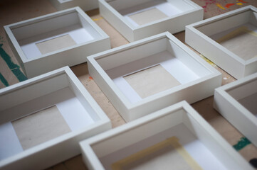 Many white wooden frames, exhibition day, preparation