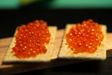 Red caviar on bread rolls close-up. Selective focus. The concept of healthy food